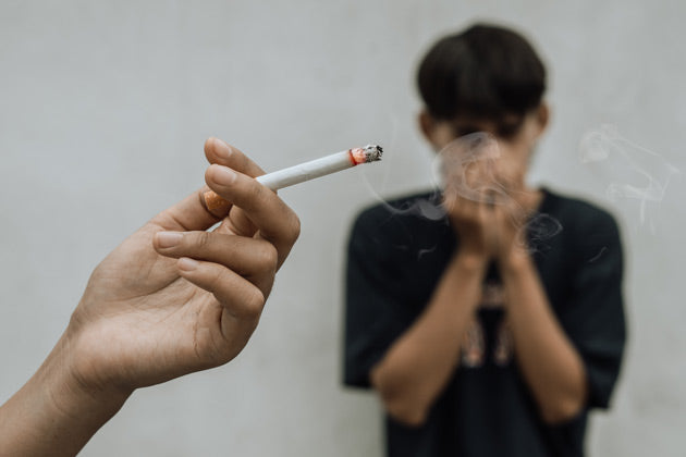 A person is hiding from cigarettes smoke 