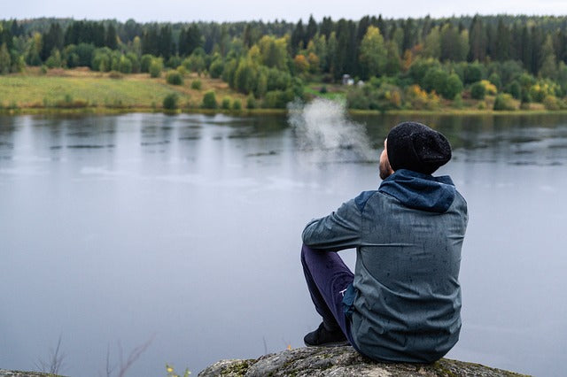 A man sitting at the edge of the river 
