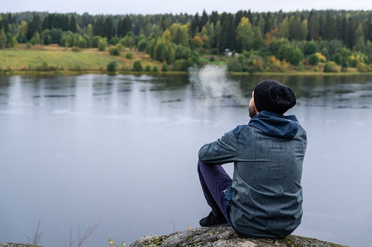A man sitting at the edge of the river 